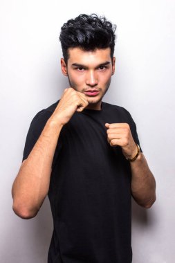 Dövüş pozisyonundaki adam siyah t-shirt duygularını taklit eder.