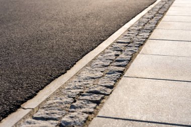 Asfalt Yol Kenarı Taştan Kaldırım ve Beton Kaldırımla Gün Işığı Altyapı Taşımacılığı Altyapısı Arkaplanı için Şehir Caddesi Yüzey Detayı