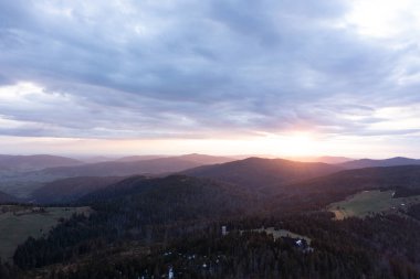 Gün batımında sakin dağ manzarası Yuvarlanan tepeler ve yumuşak akşam ışığı