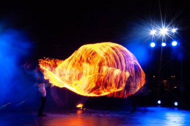 Parlak Turuncu Alevler ve Koyu Mavi Sahne Arkaplanındaki Hareketli Sahne Gösterileri. Yaratıcı Uzun Pozlama