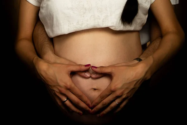 Couple Hands Forming Heart On Pregnant Belly Showing Love Family Expecting Baby Together
