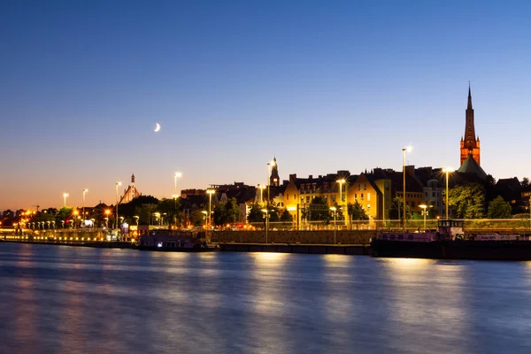 Evening City Landscape With Moon And Lights Reflecting In The River