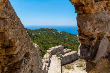Stone Castle Ruins With View Forest Hills And Blue SeaVew On Rhodes Greece. Landscape Travel Adventure Sightseeing