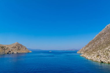 Çıplak Kaya Sahili Arasındaki Deniz Mavisi Su. Geniş Deniz Burnu ve Mavi Gökyüzü. Kopyalama Alanı ile Doğayı Seyahat Arkaplanı