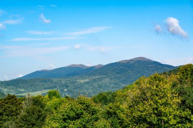 Yaz mevsiminde Parlak Mavi Gökyüzü Altında Orman Tepeleriyle Dağ Manzarası