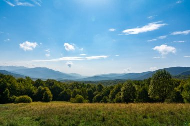 Geniş Dağ manzarası Yeşil Ormanlar ve Parlak Mavi Yaz Gökyüzü
