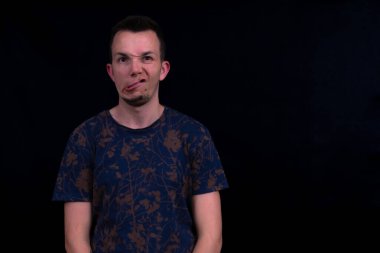 Komik, çarpık ağızlı yüz ifadesi, mizah içeriği için siyah arka planda aptal bir portre. Aptal surat.