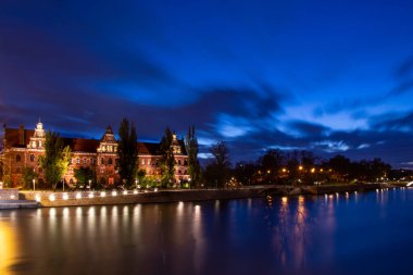 Tarihi Binası ve Su Yansımaları ile Gece Riverside Şehri. Uzun Maruz Kalma Mavi Saatli Şehir.