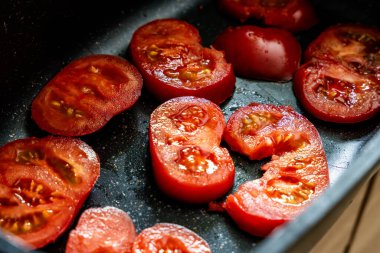 Fırına dayanıklı taze domatesler yakın çekim, sağlıklı yemek malzemeleri ve vejetaryen gıda konsepti.