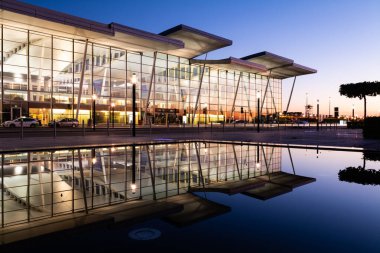 Wroclaw Havaalanı Terminal Binası. Gün batımında cam cephe ve suya yansıma ile birlikte.