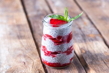 Çiğ vegan tatlı: Chia tohum puding ahşap arka plan üzerinde çilek ile 