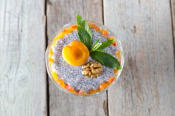 RAW vegan dessert: Chia frön pudding med aprikoser och mynta på en trä bakgrund, ovanifrån. — Stockfoto
