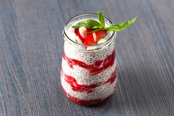 Rauwe veganist dessert: Chia seeds pudding met aardbeien op een houten achtergrond — Stockfoto