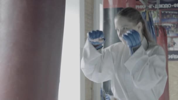 Lento movimento Taekwondo menina trens com saco de perfuração no ginásio — Vídeo de Stock