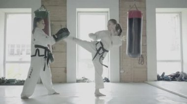 İki Taekwondo kızlar tren için bir Kick boks pençe üzerinde