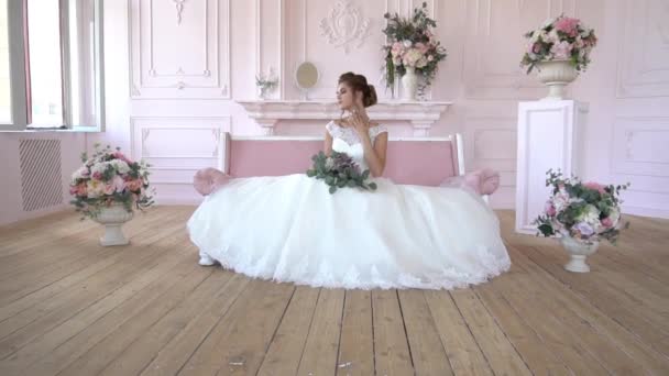 Ein Mädchen Einem Schönen Weißen Kleid Sitzt Auf Dem Bett — Stockvideo