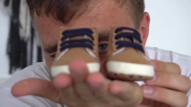 Slow Motion Imagen Recortada Del Hombre Sosteniendo Zapatos Recién Nacidos — Vídeo de stock