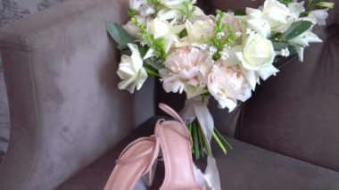 Lüks bir fotoğraf stüdyosunda, beyaz bir koltukta düğün buketi. Şakayık Buketi