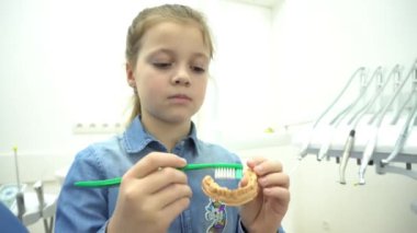 4K kızı dişçide dişlerini fırçalamayı öğreniyor.