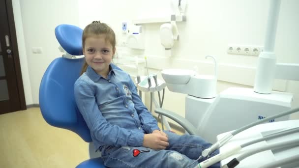 Nettes Kind Sitzt Zahnarztstuhl Und Schaut Die Kamera — Stockvideo