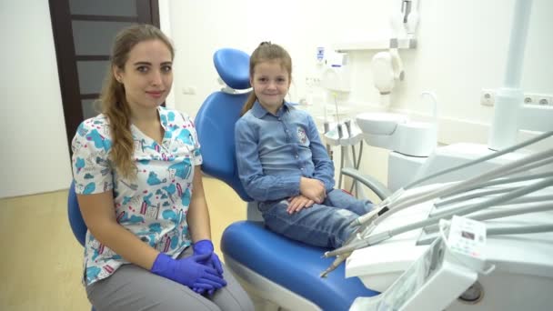 Nettes Kleines Mädchen Sitzt Auf Dem Zahnarztstuhl Und Hat Eine — Stockvideo