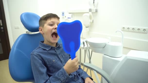 4K年幼儿在牙科诊所接受牙科治疗后在镜子中检查牙齿 — 图库视频影像