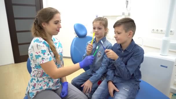 Dentista Les Dice Los Niños Cómo Cepillarse Los Dientes — Vídeos de Stock