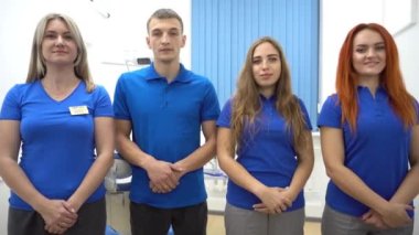 4K Neşeli diş hekimi grubu ve asistanları diş hekiminde duruyorlar.