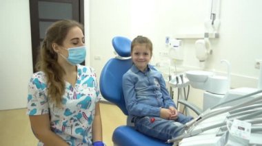 Yavaş Hareketli Kadın dişçi ve küçük kız hasta baş parmak işareti gösteriyor 