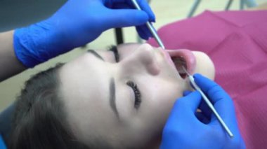 Hastanın ağız muayenesi için hazırlanan dişçiyi yakından çek.