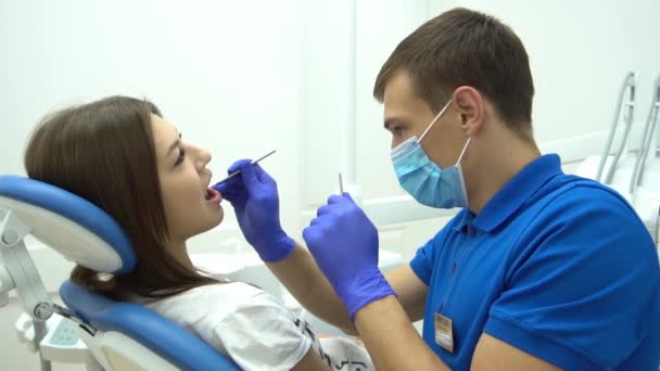 Ritratto Slow Motion Giovane Dentista Maschera Esaminando Denti Cliente Femminile — Video Stock