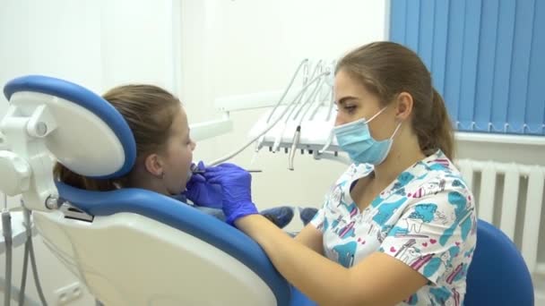 Dentista Trata Los Dientes Una Paciente Chica — Vídeo de stock