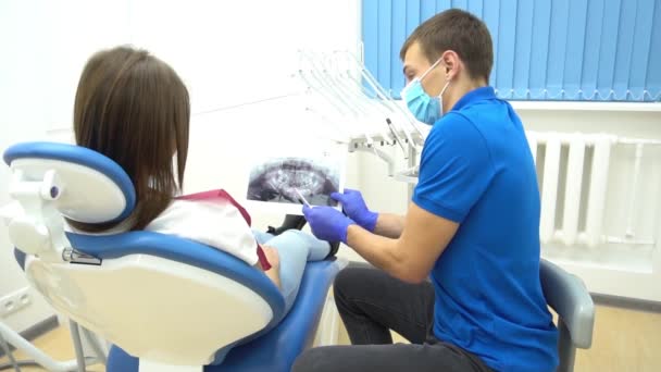 牙医向病人显示颌骨X光扫描的慢动作后视镜照片 — 图库视频影像