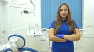 Kadın dişçinin Yavaş Hareket Portresi. Ofisinde dikiliyor ve...