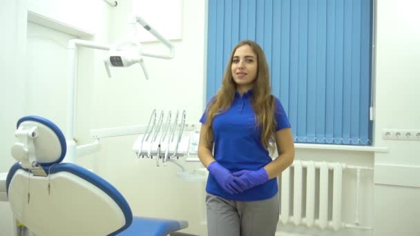 缓慢运动的欧洲中层牙医妇女站在牙齿上的时候露出了大拇指 — 图库视频影像