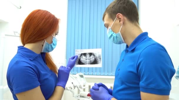 Tandläkare Som Håller Tänder Röntgen Och Sjuksköterska Tar Anteckningar Urklipp — Stockvideo