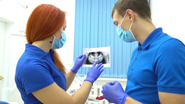 牙科诊所慢动作牙科医生及辅助X光分析 — 图库视频影像