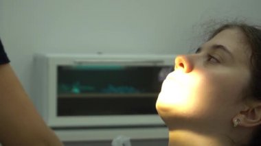 Tıp merkezinde dişçi koltuğunda oturan genç bir kadının Yavaş Çekim Görüntüsü