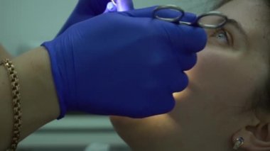 Slow Motion Dişçi modern klinikte hastanın dişlerini muayene ediyor. Kozmetik dişçisi
