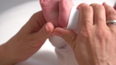 Yeni doğmuş minik bacaklar. Anne küçük ayakları tutuyor. Sağlık sigortası konsepti. Tanınmayan 