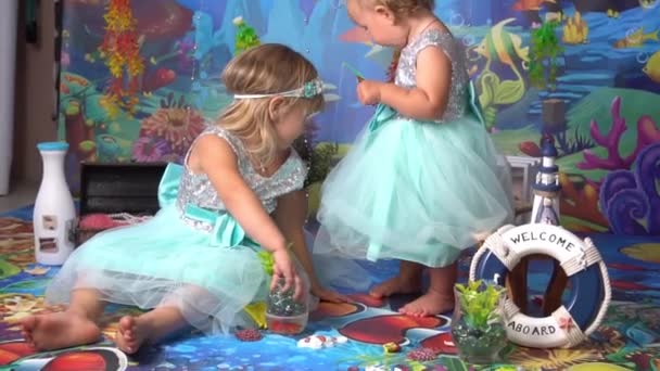 Две Маленькие Блондинки Играют Раковинами Звездами Якорем Фонарями Морпехами — стоковое видео