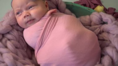 4K, çocuk mor bir battaniyenin üzerinde yatıyor. Ortanca çiçeklerinde yeni doğmuş bir kız bebek.