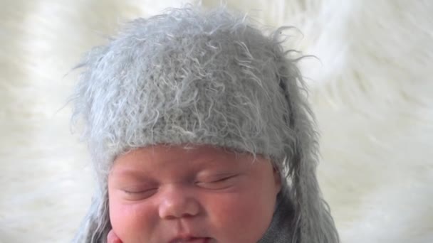 头戴针织灰帽的可爱新生儿正在睡觉 裹着布 躺在床上 — 图库视频影像
