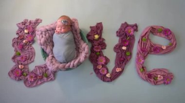 Pembeden yapılmış beyaz arka planda çiçekler ve yeni doğmuş bir bebek.