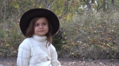 Slow Motion Autumn kadını. Beyaz kazaklı ve şapkalı kız doğa parkında