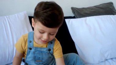 Düşünceli çocuk portresi, yatakta düşünen çocuk başka tarafa bakıyor. 