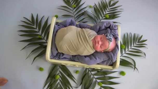 スローモーション新生児は花の装飾とヤシの葉を持つベッドで眠る — ストック動画