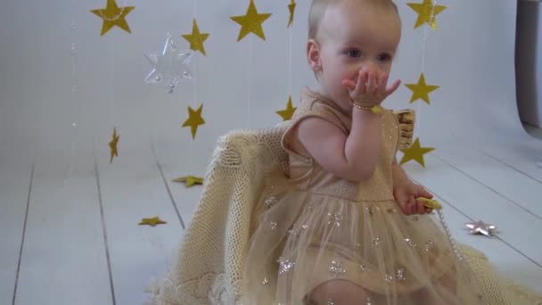 1歳の赤ん坊は誕生日を祝う 金色のドレス 紙黄星 — ストック動画