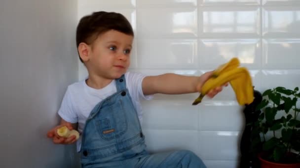 Маленький Хлопчик Сидить Столі Фруктами Кухні Вдома — стокове відео
