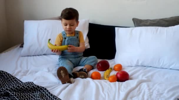 Schattige Jongen Zitten Bed Gekleed Casual Kleding Glimlachen Tijdens Het — Stockvideo